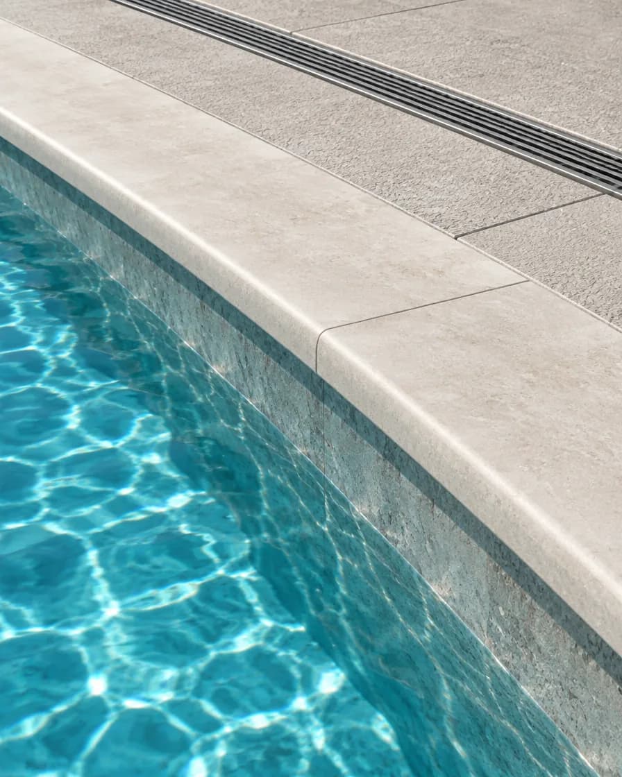 Illustration of stone pool coping meeting a non-slip deck with a linear deck drain behind it